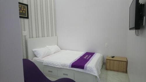 a small bedroom with a bed and a tv at Lavender Tan Thanh Hotel mini resort in Cong Thanh (3)