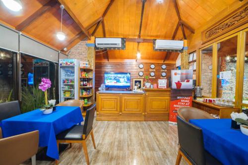 a restaurant with blue tables and chairs and a counter at RedDoorz Plus @ Starhomes Olivianville in Tarlac