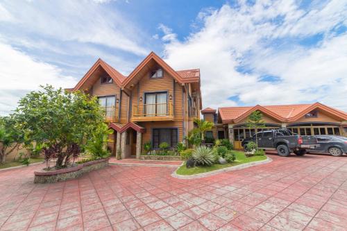 a house with a car parked in front of it at RedDoorz Plus @ Starhomes Olivianville in Tarlac