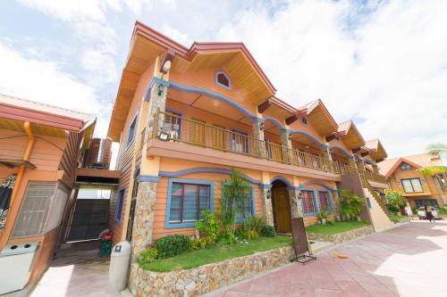 a large house with a balcony on a street at RedDoorz Plus @ Starhomes Olivianville in Tarlac