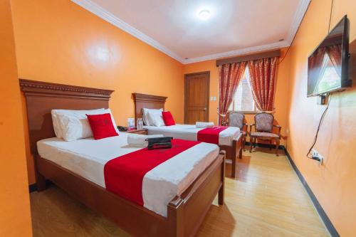 a hotel room with two beds and a chair at RedDoorz Plus @ Starhomes Olivianville in Tarlac