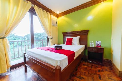 a bedroom with a bed and a large window at RedDoorz Plus @ Starhomes Olivianville in Tarlac