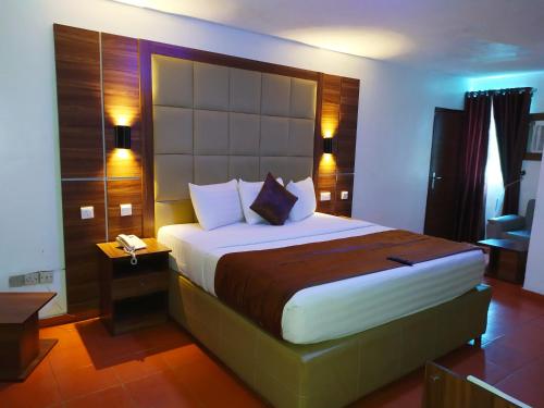 um quarto com uma cama grande num quarto em Presken Hotel (Awolowo way) em Ikeja