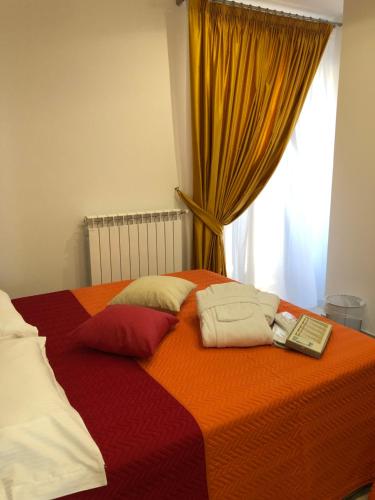 Bett mit Kissen und Fernbedienung in der Unterkunft Agriturismo Casa Giusta in Centola