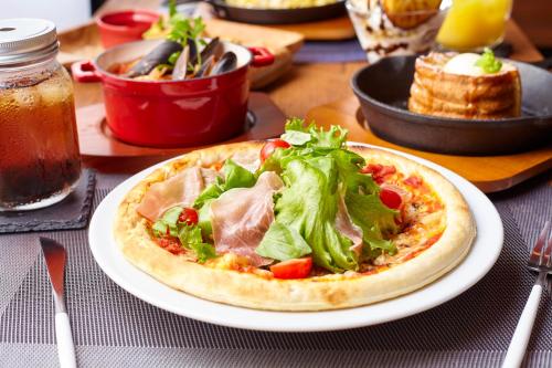 a pizza sitting on a plate on a table at HOTEL LOVE in Nagoya