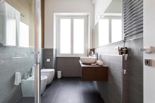 a bathroom with a toilet, sink, and tub at Milano Manzoni CLC Apartments in Milan