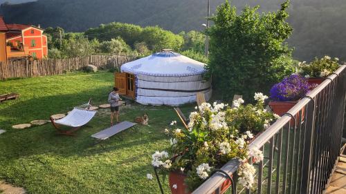 a woman and a dog in a yard with a yurt at Casa Balsamo in Borzonasca