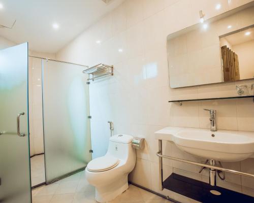 a bathroom with a toilet and a sink and a mirror at A25 Hotel - 15 Hàng Than in Hanoi