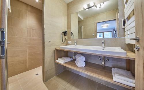 a bathroom with a sink and a mirror at AlpenParks Hotel & Apartment Sonnleiten in Saalbach Hinterglemm