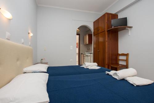 een slaapkamer met 2 bedden met blauwe lakens en witte kussens bij Villa Phoenix in Laganas