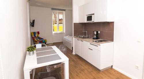 a kitchen with white cabinets and a white counter top at Apartments and Rooms Jospino in Mali Lošinj