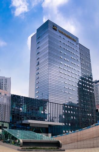 a tall glass building in a city at Chongqing Liyuan Hotel in Chongqing