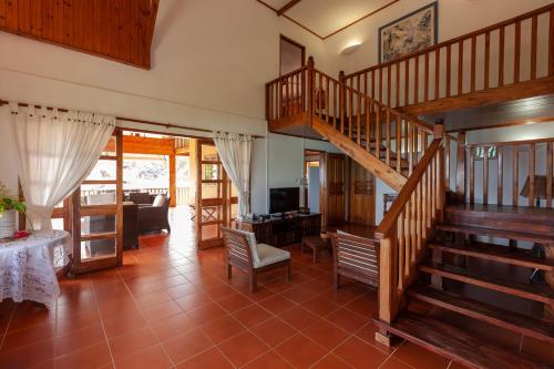 a living room with a staircase in a house at La Villa Mille Etoiles in Baie Sainte Anne