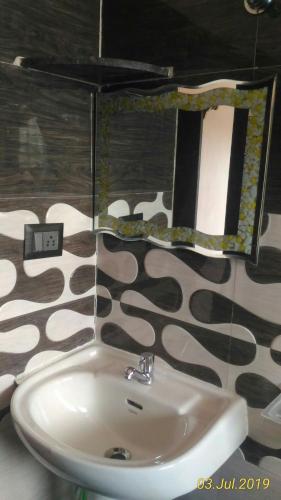 a bathroom with a sink and a mirror at Gopi Homestay in Hampi