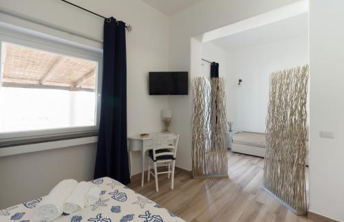 a bedroom with a bed and a desk and a mirror at B&B Sunrise in Santa Marina Salina