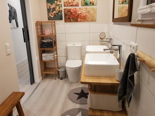 een badkamer met een wastafel en een toilet. bij Große, helle Ferienwohnung mit 2 Balkonen auf dem Bauernhof in der Lüneburger Heide in Oetzen