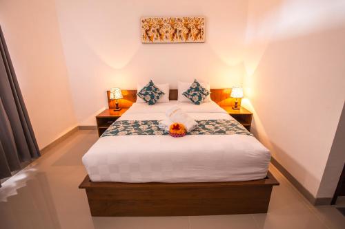 a bedroom with a bed with two lamps and a flower on it at Arie Guest House in Nusa Penida