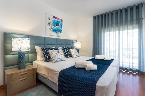 a bedroom with a large bed with a blue headboard at Sea La Vie Beach & Golf Apartment in Lagos