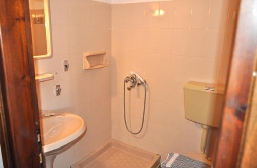 a bathroom with a shower and a toilet and a sink at Pension Marina in Kinira