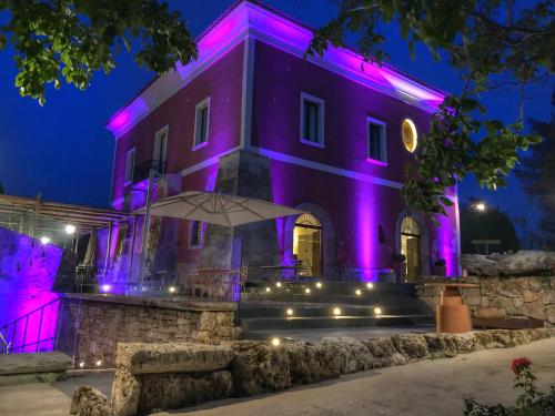 una casa con luci viola sopra la notte di Tenuta Duca Marigliano Boutique Hotel a Paestum