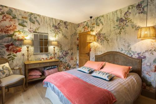 1 dormitorio con 1 cama con papel pintado con motivos florales en Côté Rivière en Nevy-sur-Seille