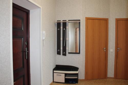 a room with a door and a stool and a mirror at Уютная двушка in Elista