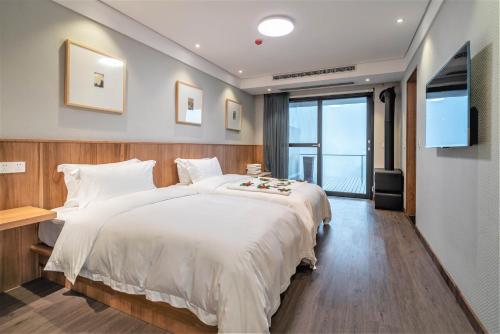 a bedroom with a large white bed and a television at Misty Wonderland ,Yangshuo Xingping in Yangshuo