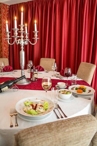 a table with plates of food and glasses of wine at Hotel Putnik in Novi Sad
