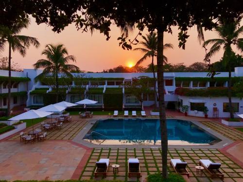 a hotel with a pool and a sunset in the background at Trident Bhubaneswar in Bhubaneshwar