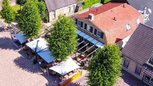 een bovengronds uitzicht op een gebouw met bomen en tafels bij Hotel Restaurant Boschlust in Oudemirdum