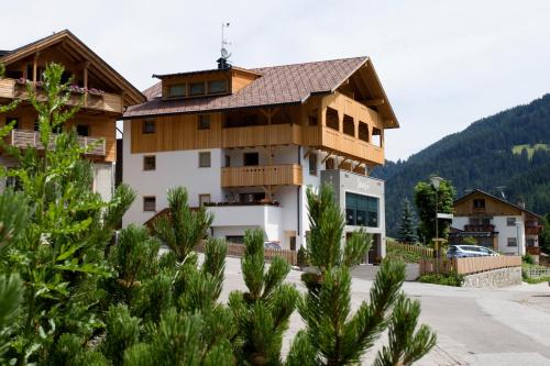 duży budynek z drzewami przed nim w obiekcie Berghotel Sanví w mieście San Martino in Badia