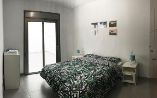 ラスパルマス・デ・グランカナリアにあるFlatguest - Cozy Beachのベッドルーム1室(緑と黒の掛け布団付きのベッド1台付)