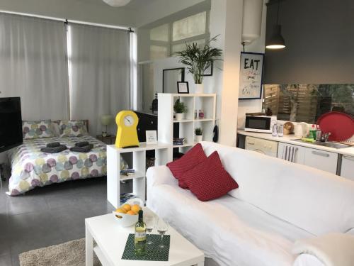 a living room with a white couch and a bed at Flatguest - Glass House in Santa Brígida