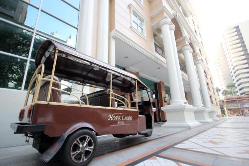 a small golf cart parked in front of a building at Hope Land Hotel Sukhumvit 24 in Bangkok