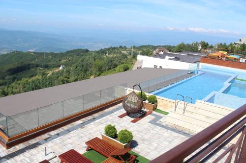 uma piscina no topo de um edifício com uma montanha em As Lux Apartmani Kopaonik em Kopaonik