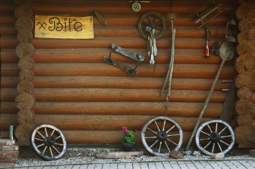 a wooden wall with twookedoked wheels and a bike sign at Beibuki in Naujene