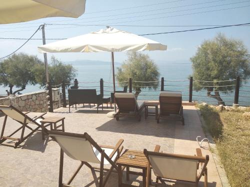 a patio with a table and chairs and an umbrella at C-view apartments in Megalochori