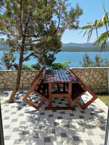 a picnic table sitting on a patio near the water at Apartments Lukrecia in Neum