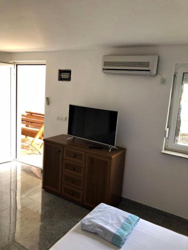 a living room with a tv on a dresser at Apartments Lukrecia in Neum