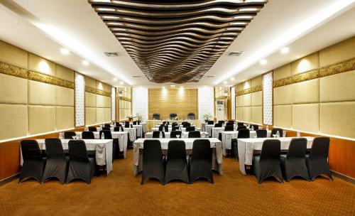 a conference room with tables and chairs in it at Grand Inna Tunjungan Hotel Surabaya in Surabaya