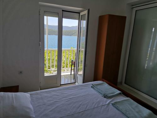 a bedroom with a bed and a large window at Apartments Lukrecia in Neum