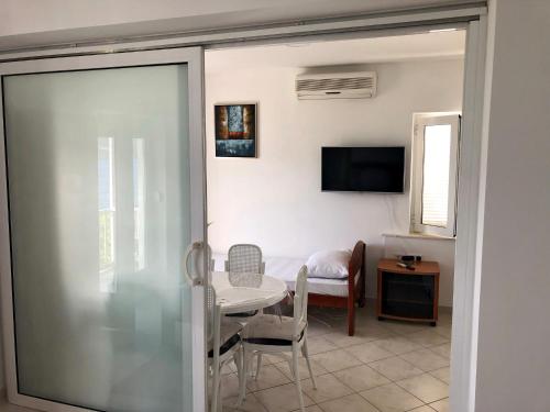 a dining room with a table and a television at Apartments Lukrecia in Neum
