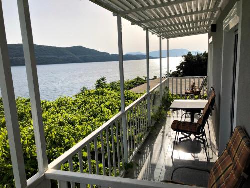 a balcony with a table and chairs and the water at Apartments Lukrecia in Neum