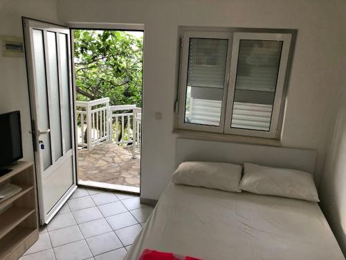 a bedroom with a bed and a sliding glass door at Apartments Lukrecia in Neum