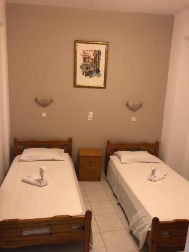 two twin beds in a room with a picture on the wall at Anthoulis Studios in Kefalos