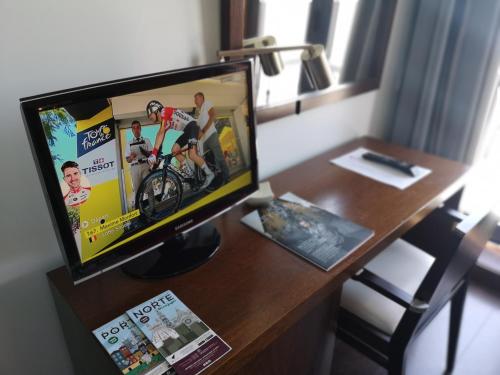a computer monitor sitting on top of a desk at Hotel Portas De Santa Rita in Ermesinde
