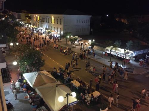 a crowd of people standing on a street at night at B&B Centrale in Tortolì
