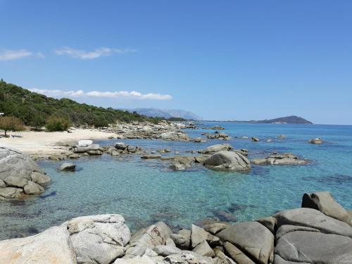 a rocky beach with blue water and rocks at B&B Centrale in Tortolì