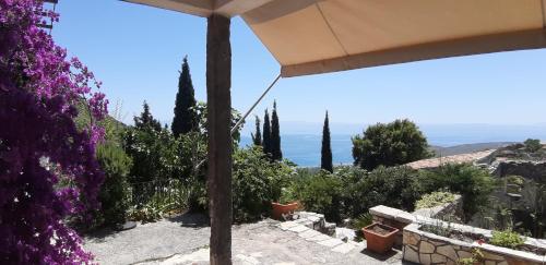 a view from the patio of a house with purple flowers at Les Villas de Qeparo in Qeparo