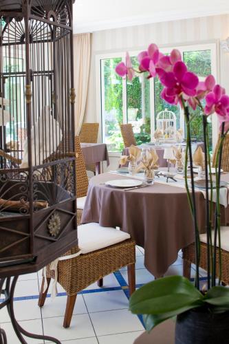 a dining room with a table with purple flowers at Logis Auberge Du Centre in Chitenay